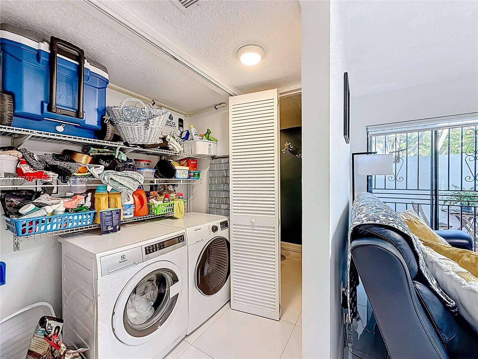 1291 SW 124th Court, #19-B, Miami, FL 33184 Laundry area featuring wire shelving, white louvered closet door, and tile flooring