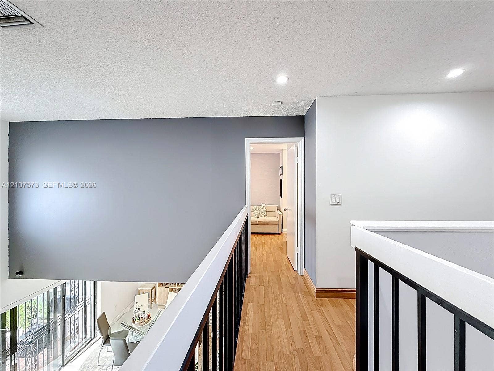 1291 SW 124th Court, #19-B, Miami, FL 33184 Hallway featuring wood-finish flooring, metal vertical-bar railing, and recessed ceiling lighting