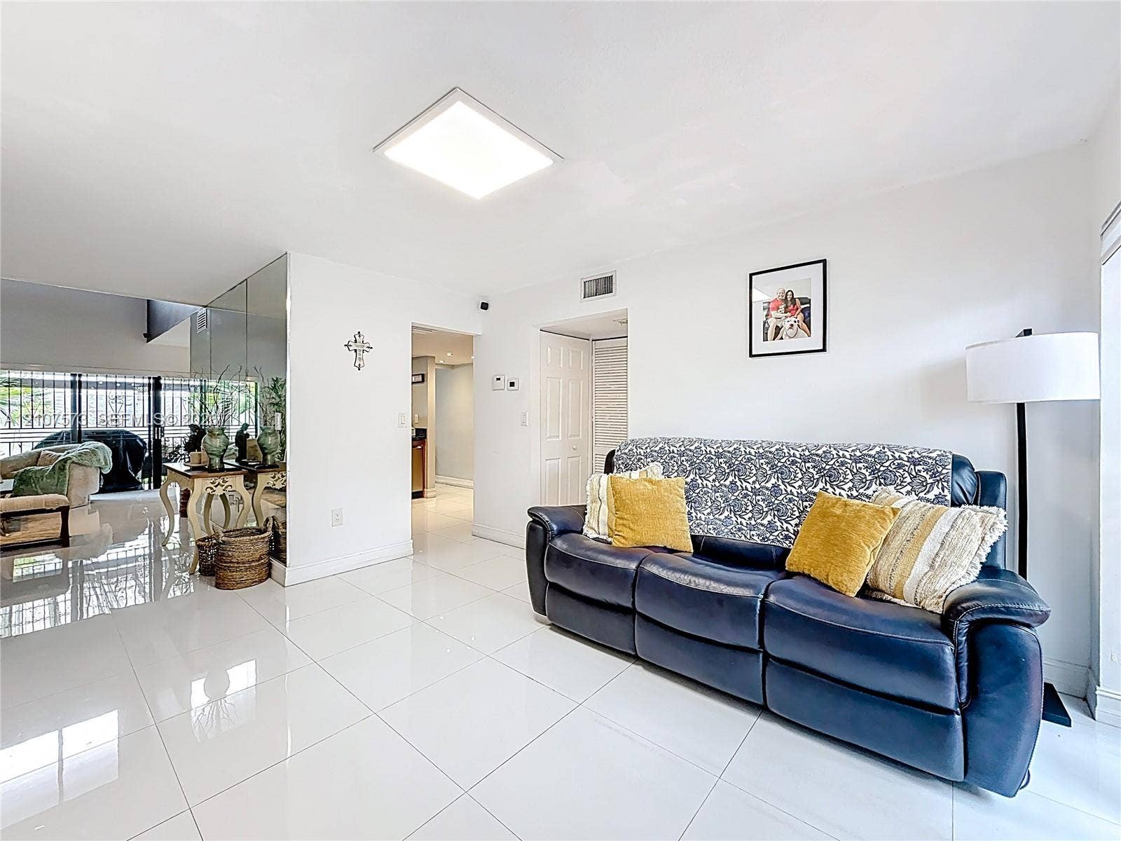 1291 SW 124th Court, #19-B, Miami, FL 33184 Polished porcelain tile flooring, mirrored wall accents, and recessed square lighting fixture