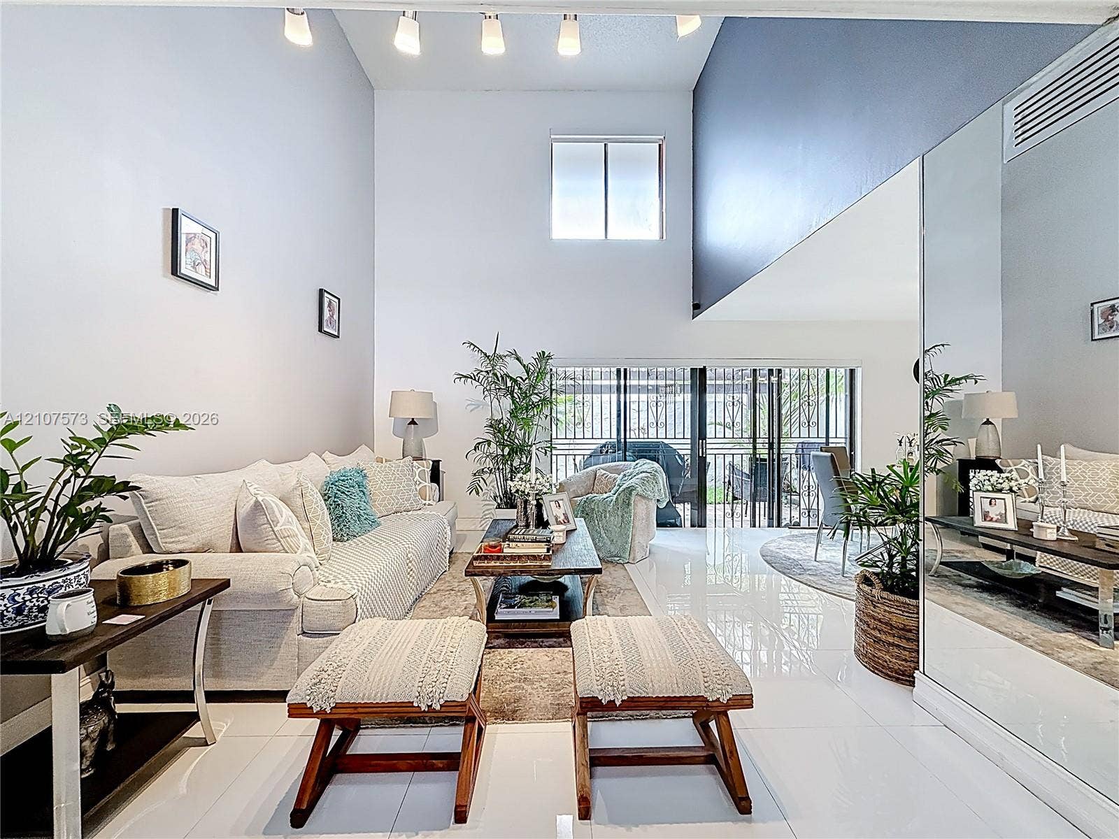 1291 SW 124th Court, #19-B, Miami, FL 33184 Double-height ceilings, polished tile flooring, full-wall mirrors, recessed track lighting, and sliding glass doors with exterior access