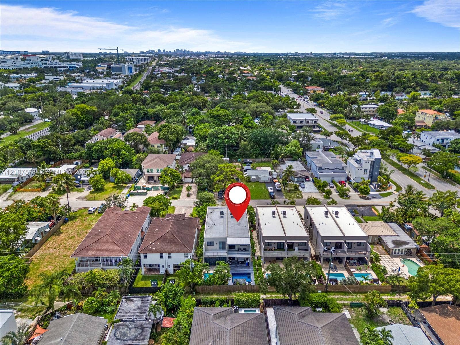 307 SW 10th Street, Fort Lauderdale, FL 33315 Multi-story residential structure featuring a flat roofline, attached balconies, private swimming pool, and dedicated hardscaped surface area