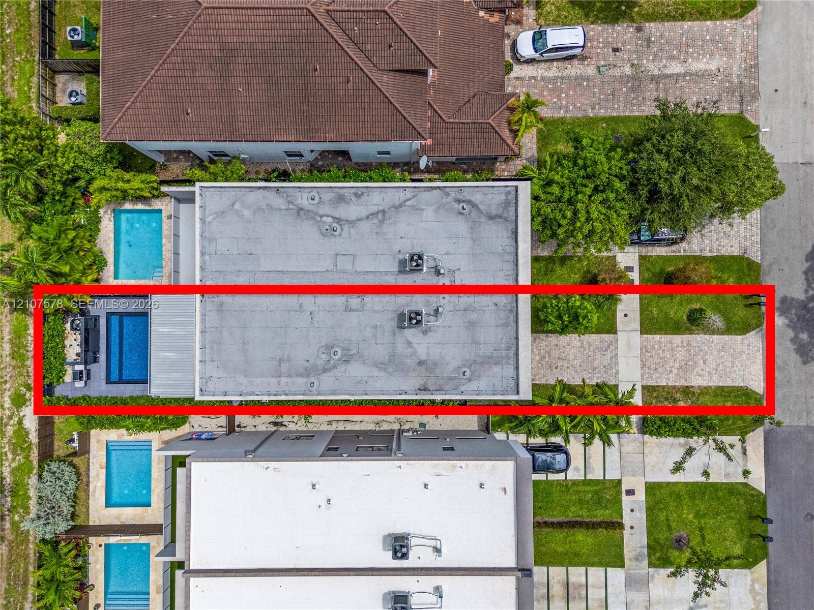 307 SW 10th Street, Fort Lauderdale, FL 33315 Aerial view of residential property featuring a rectangular swimming pool, concrete hardscaping, paved driveway, and established perimeter landscaping