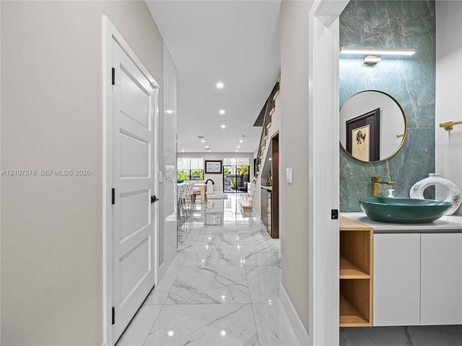 307 SW 10th Street, Fort Lauderdale, FL 33315 Hallway featuring large-format tile flooring and recessed lighting, with a powder room showcasing a green stone slab backsplash, vessel sink, and built-in vanity cabinet