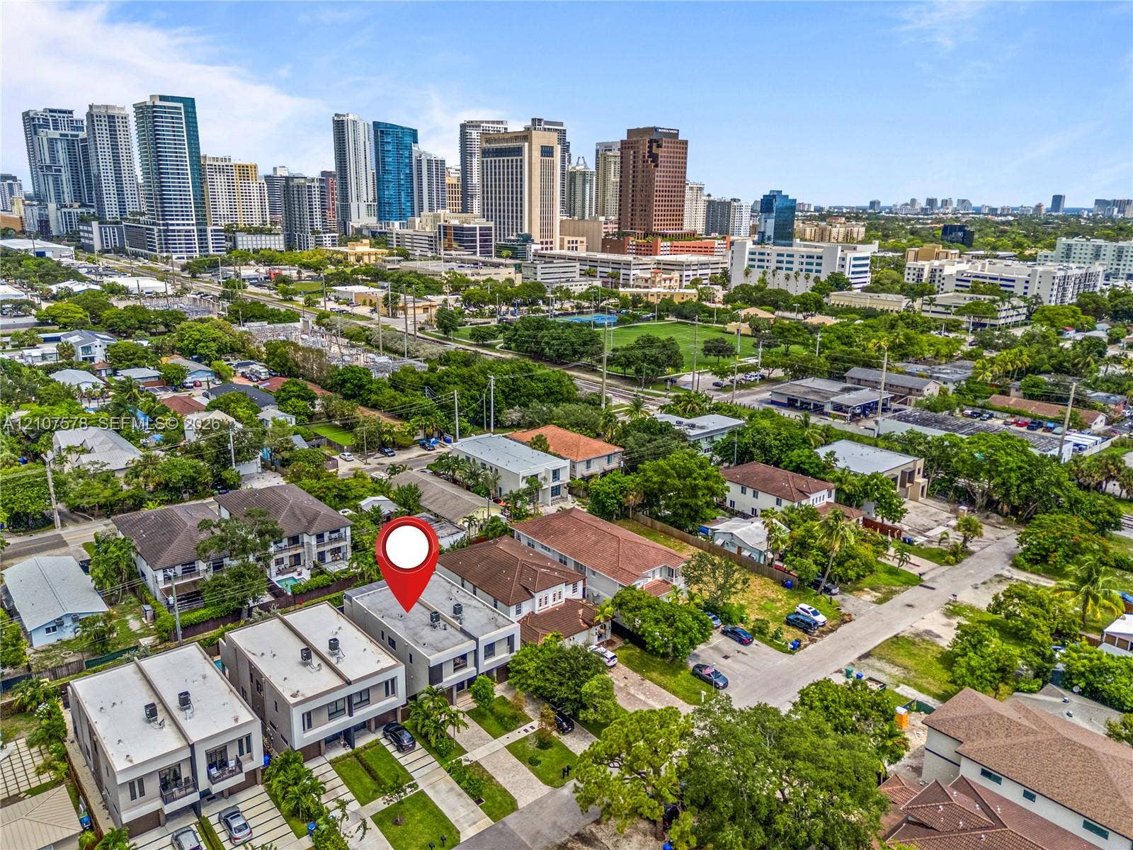 307 SW 10th Street, Fort Lauderdale, FL 33315 Aerial view of modern multi-story residential structures featuring flat rooflines, integrated balconies, and paved driveways