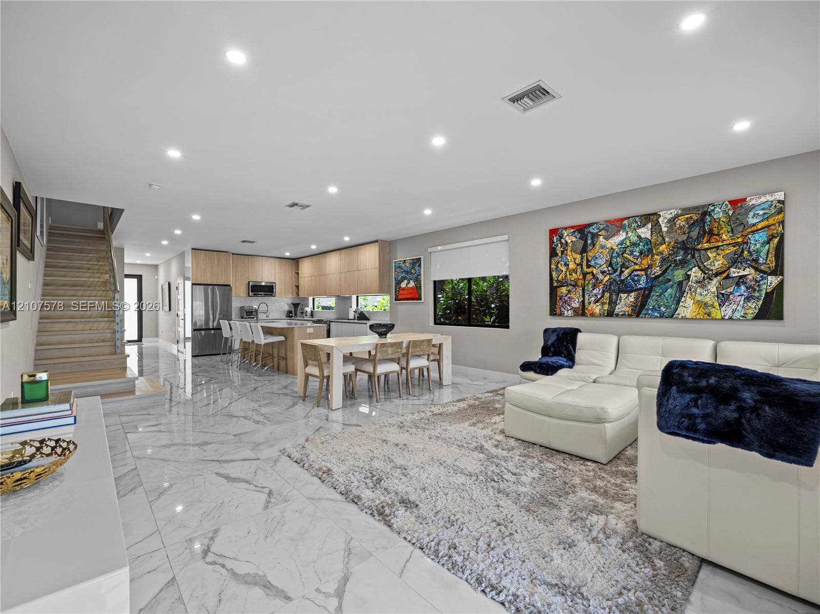 307 SW 10th Street, Fort Lauderdale, FL 33315 Open concept floor plan featuring stone-finish flooring, recessed lighting, a kitchen with flat-panel cabinetry, and a tiered staircase