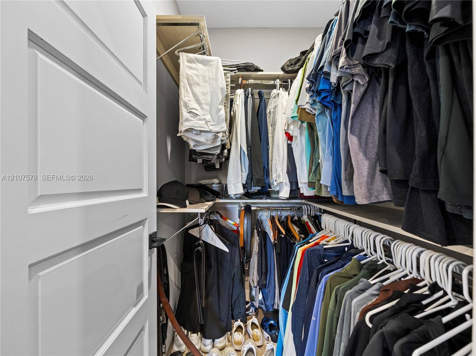 307 SW 10th Street, Fort Lauderdale, FL 33315 Reach-in closet featuring multi-level wood-finish shelving and integrated hanging rods