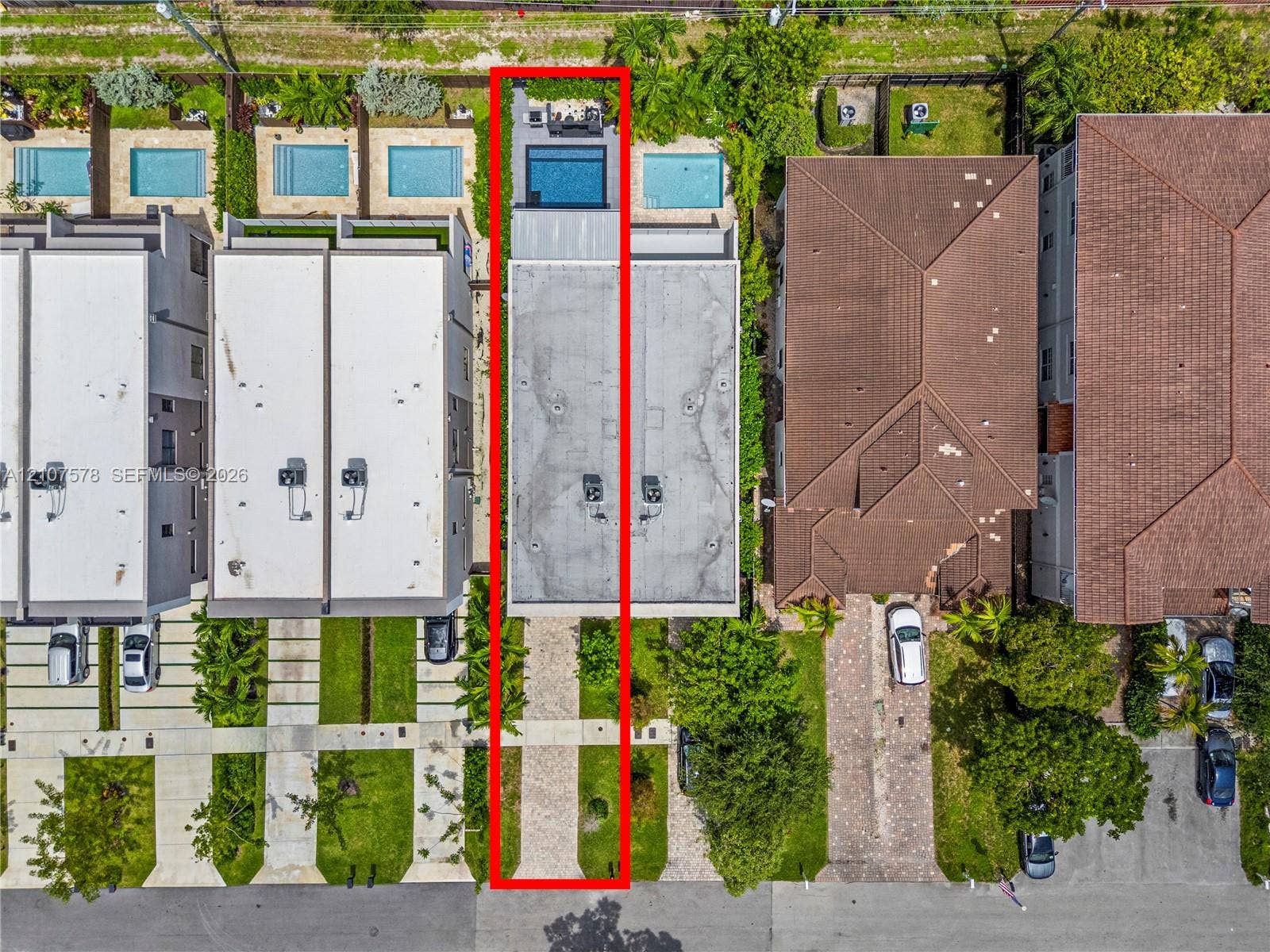 307 SW 10th Street, Fort Lauderdale, FL 33315 Aerial perspective featuring a paved driveway, a flat roofline, and a rear swimming pool with a stone-surfaced patio