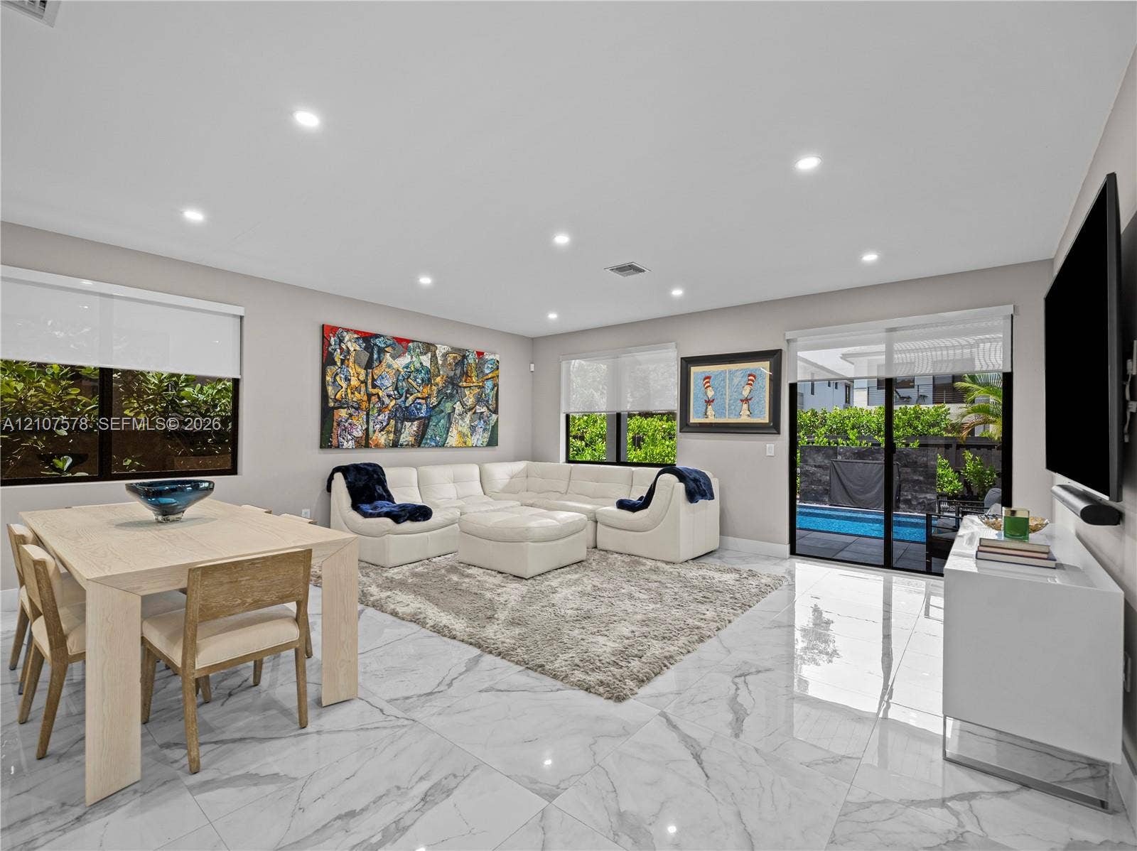 307 SW 10th Street, Fort Lauderdale, FL 33315 Open-concept living space featuring high-gloss large-format floor tiling, recessed lighting, and sliding glass doors with exterior patio and pool access