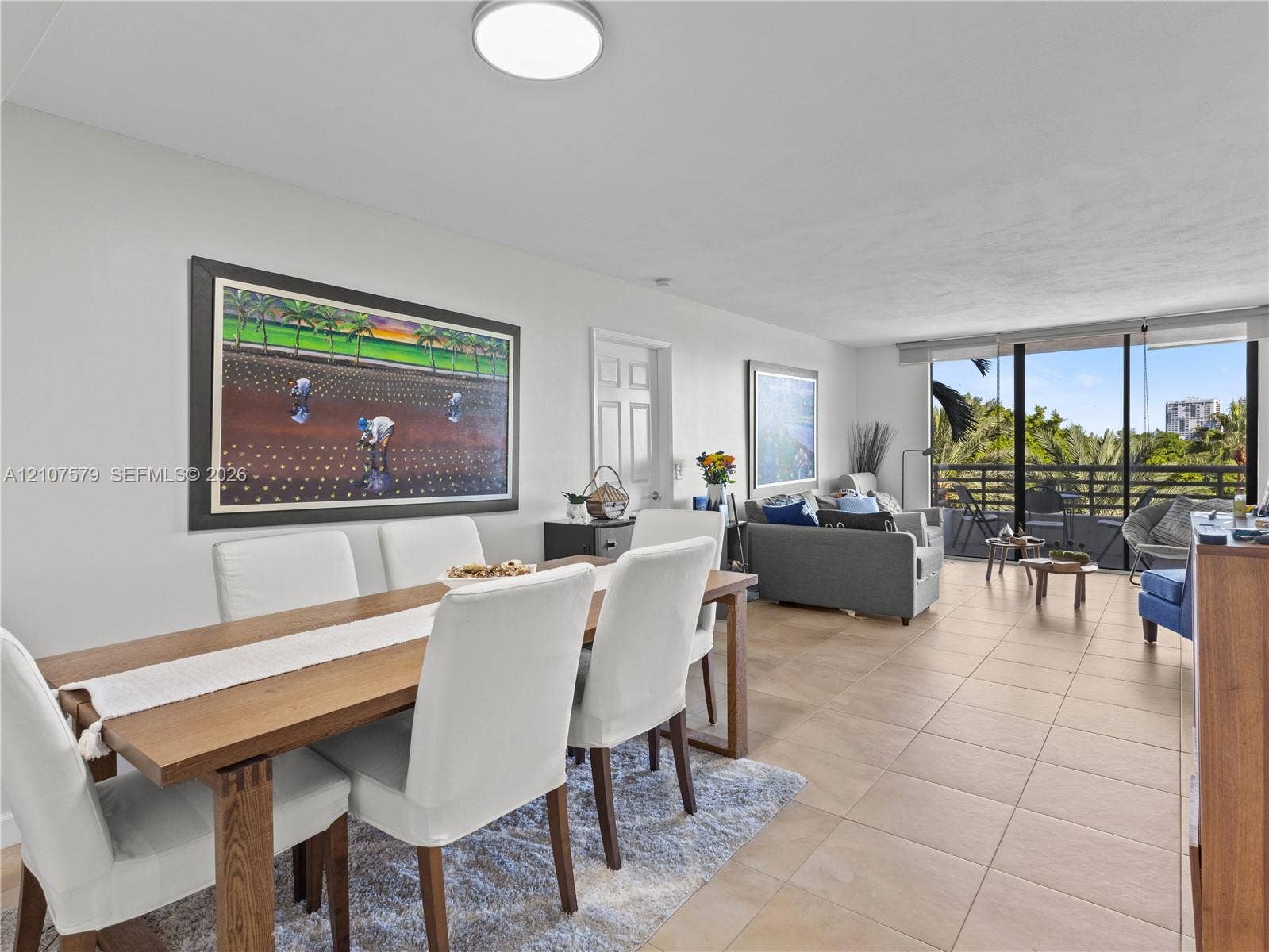 3300 NE 191st Street, #511, Aventura, FL 33180 Open-concept interior featuring large-format neutral floor tile, expansive floor-to-ceiling windows, and access to a private balcony