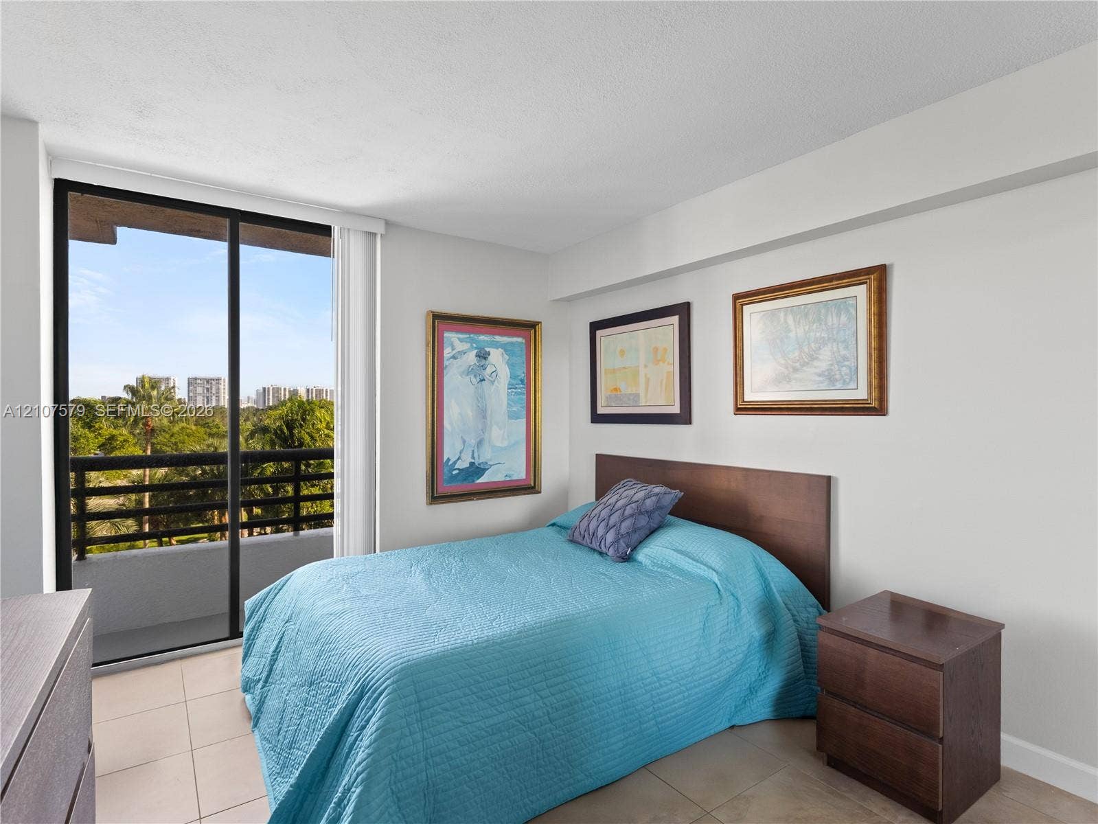 3300 NE 191st Street, #511, Aventura, FL 33180 Neutral-tone interior space featuring floor-to-ceiling sliding glass doors, neutral tile flooring, and a private balcony with horizontal railing