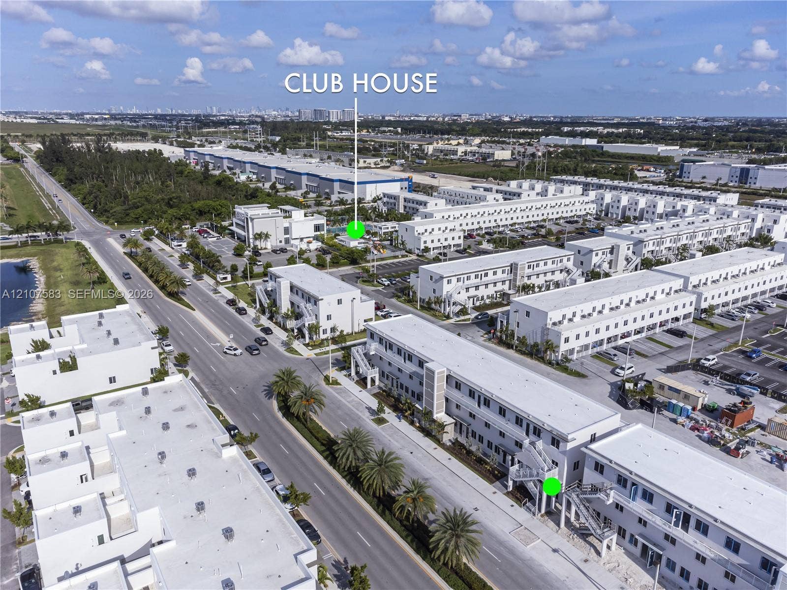 10270 NW 66th Street, #110, Doral, Doral, FL 33178 Aerial perspective of a multi-unit residential development featuring a dedicated clubhouse, paved parking areas, and mature palm landscaping