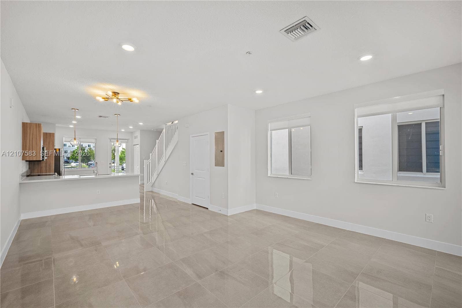 10270 NW 66th Street, #110, Doral, Doral, FL 33178 Large-format tile flooring, recessed ceiling lighting, kitchen featuring wood-finish cabinetry, breakfast bar, and staircase with wooden handrail