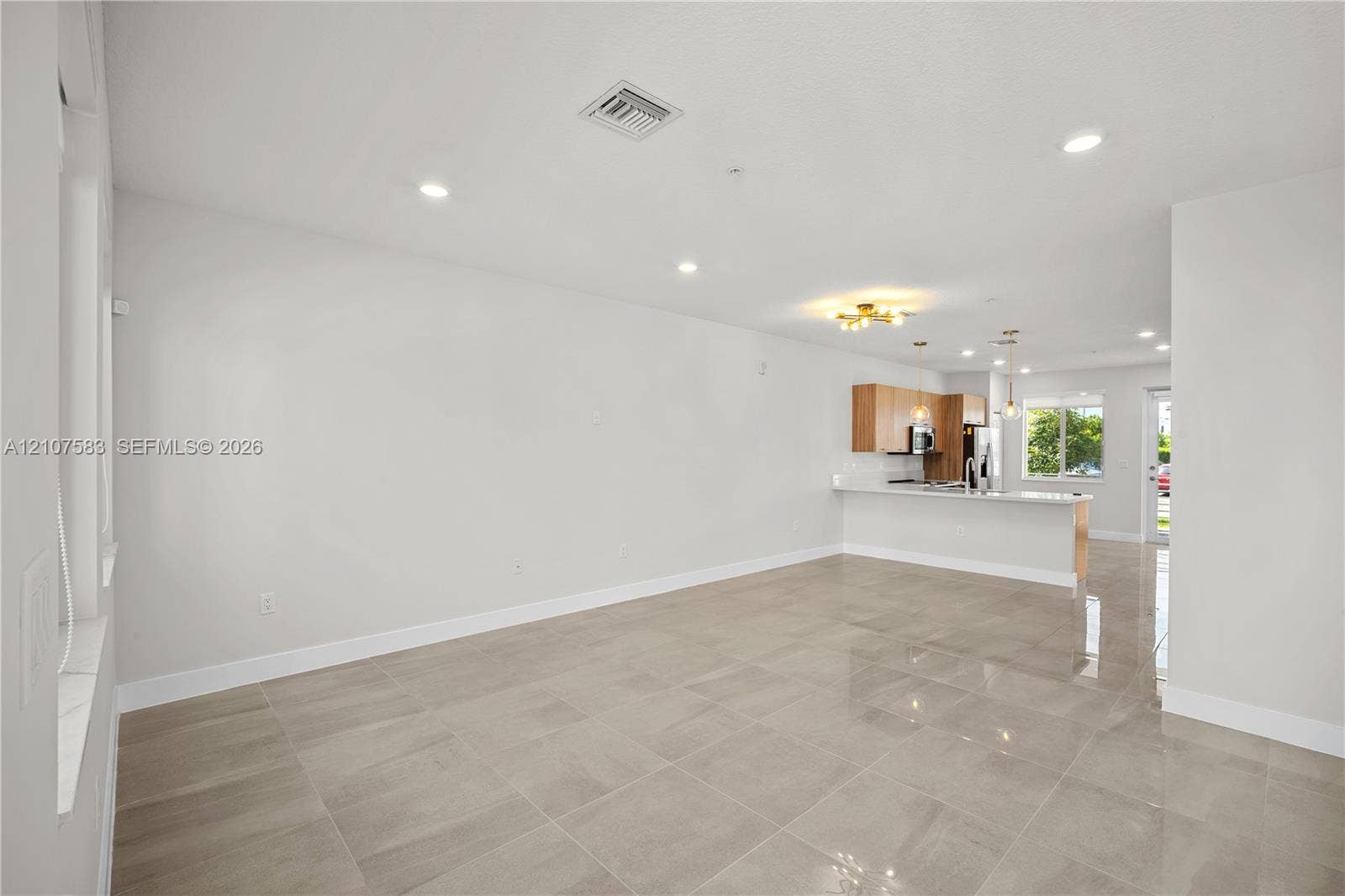 10270 NW 66th Street, #110, Doral, Doral, FL 33178 Open-concept interior featuring large-format tile flooring, recessed lighting, a kitchen island with a stone countertop, and light-toned cabinetry