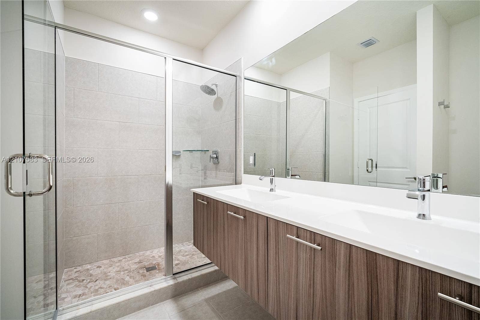 10270 NW 66th Street, #110, Doral, Doral, FL 33178 Floating vanity with wood-finish cabinetry, dual undermount sinks, quartz countertops, and a full-width mirror