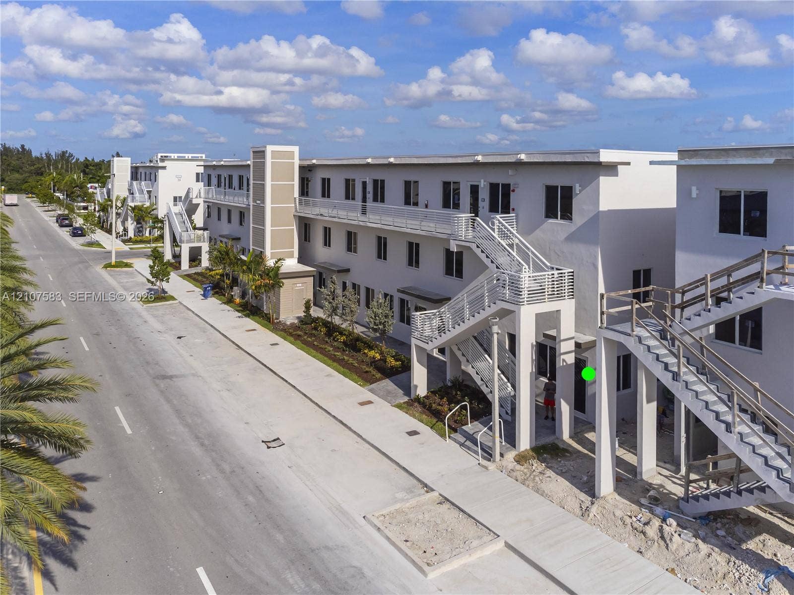 10270 NW 66th Street, #110, Doral, Doral, FL 33178 Multi-story exterior featuring light-toned stucco siding, metal staircases, exterior walkways with horizontal railings, and integrated wall-mounted lighting