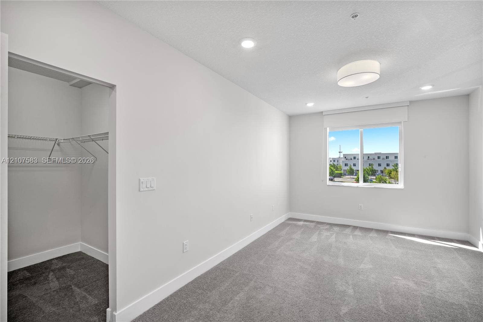 10270 NW 66th Street, #110, Doral, Doral, FL 33178 Neutral-toned room featuring wall-to-wall carpeting, recessed lighting, a ceiling-mounted light fixture, and a built-in closet with wire shelving