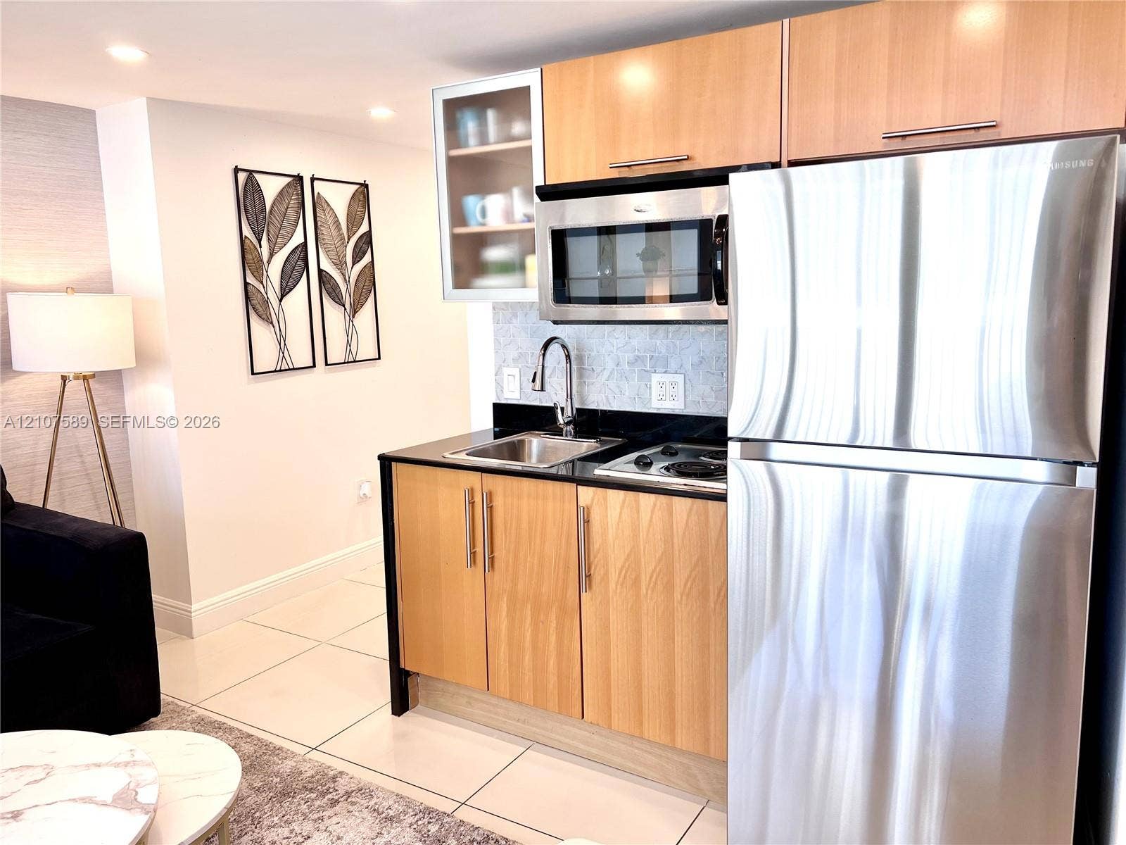 1750 N Bayshore Drive, #1218, Miami, Miami, FL 33132 Kitchenette featuring light wood cabinetry, stone countertops, stainless steel refrigerator, built-in microwave, and arched faucet