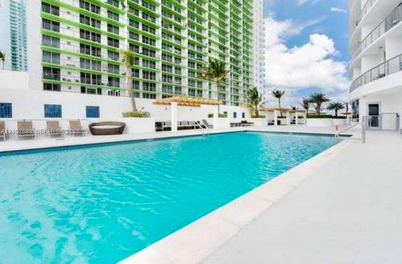 1750 N Bayshore Drive, #1218, Miami, Miami, FL 33132 Swimming pool featuring a concrete deck, built-in wooden pergola, and perimeter landscaping