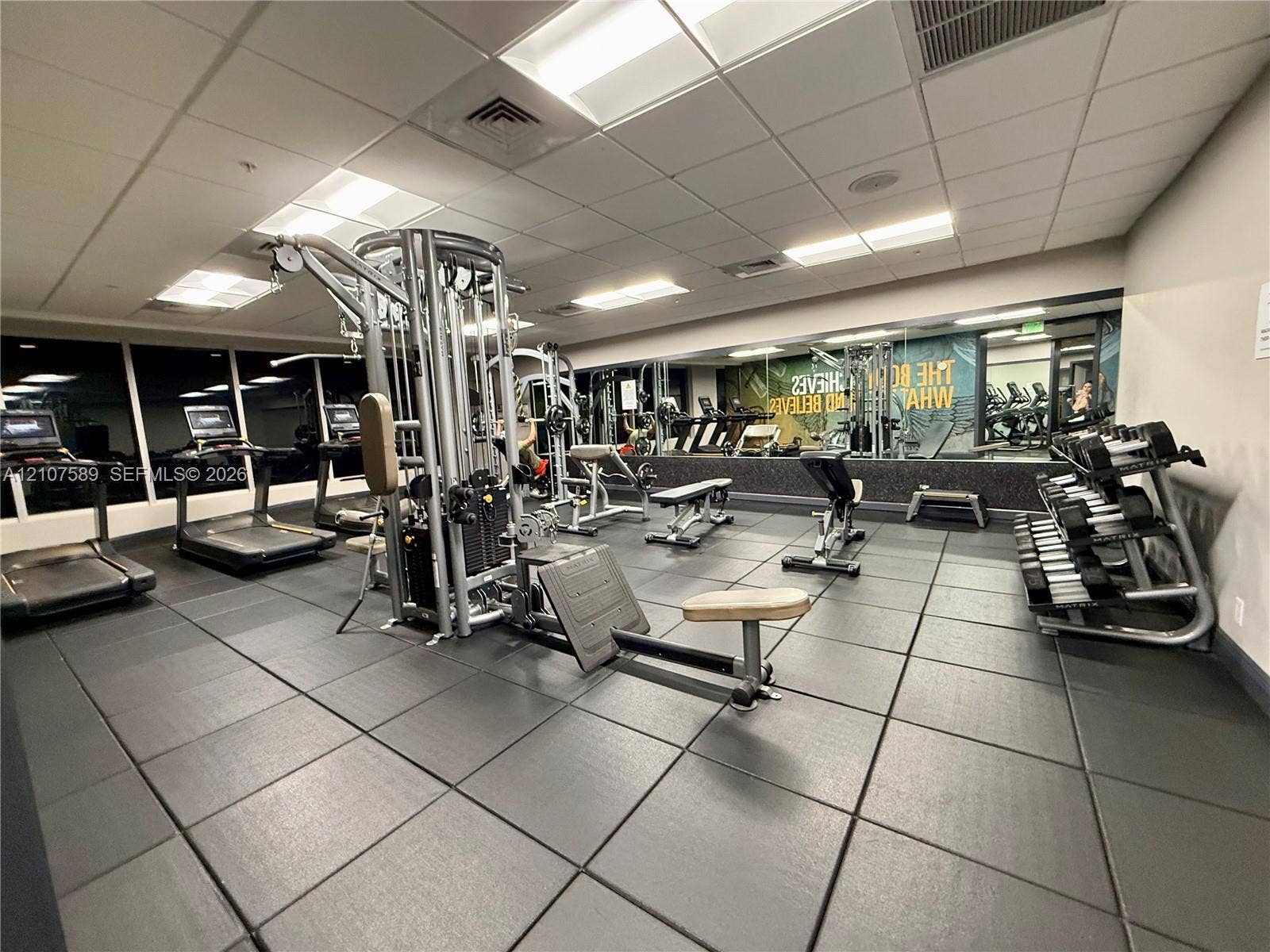 1750 N Bayshore Drive, #1218, Miami, Miami, FL 33132 Fitness center featuring black rubberized flooring, a full-length wall mirror, drop ceiling with recessed lighting, and wall-to-wall windows