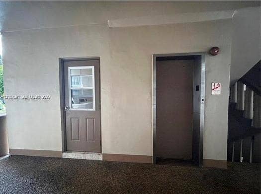 5003 NW 35th Street, #506, Lauderdale Lakes, FL 33319 Single-panel entry door with a rectangular window insert, paired with a stainless steel elevator entrance