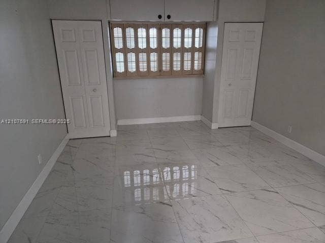 5003 NW 35th Street, #506, Lauderdale Lakes, FL 33319 Polished stone-look tile flooring, dual closets with solid-core panel doors, and window shutters