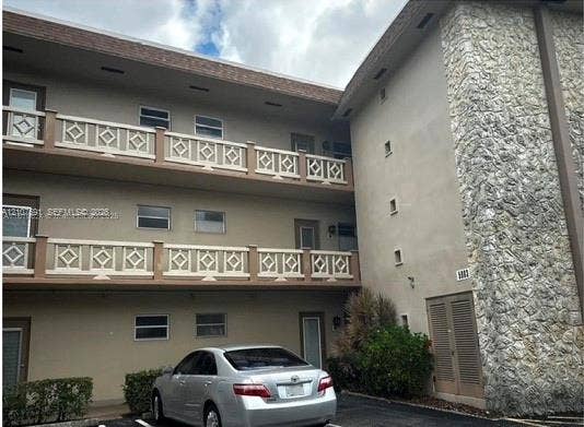 5003 NW 35th Street, #506, Lauderdale Lakes, FL 33319 Multi-story exterior facade featuring decorative geometric balcony railings and natural stone veneer accents