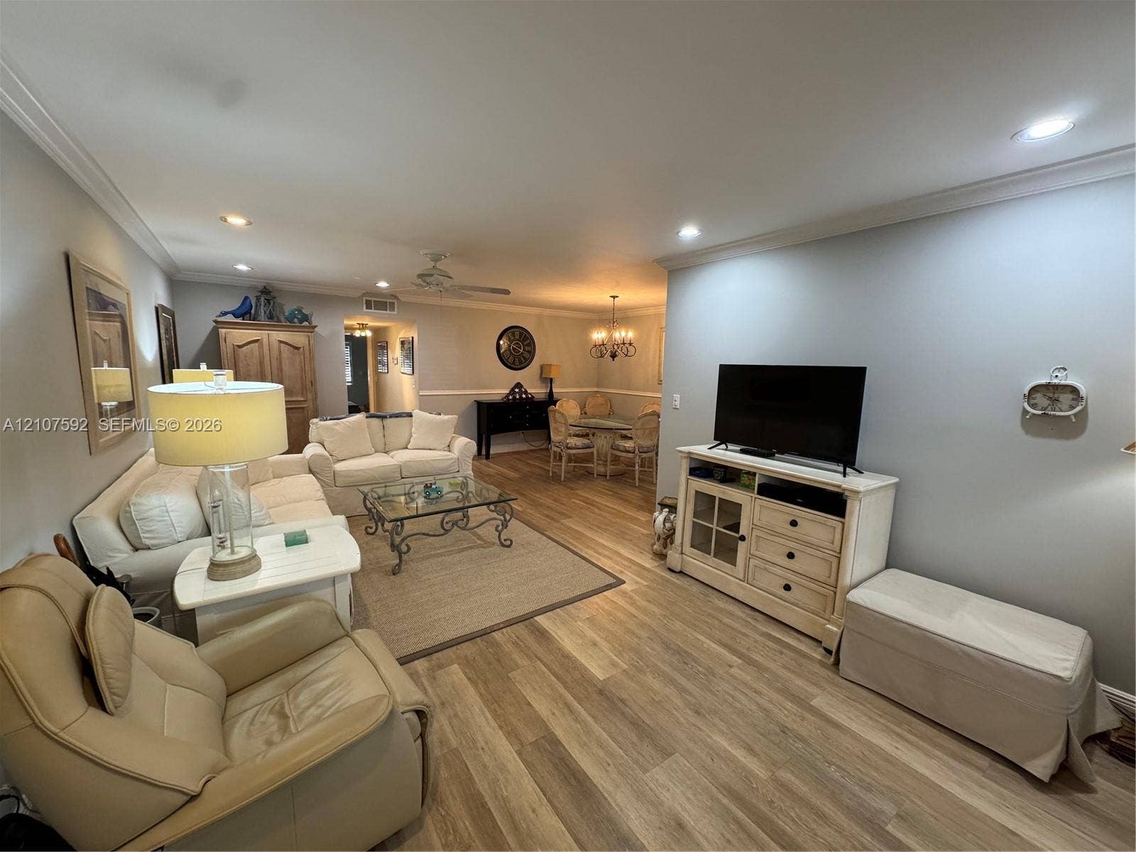 Open-concept interior featuring wood-finish flooring, crown molding, and recessed lighting
