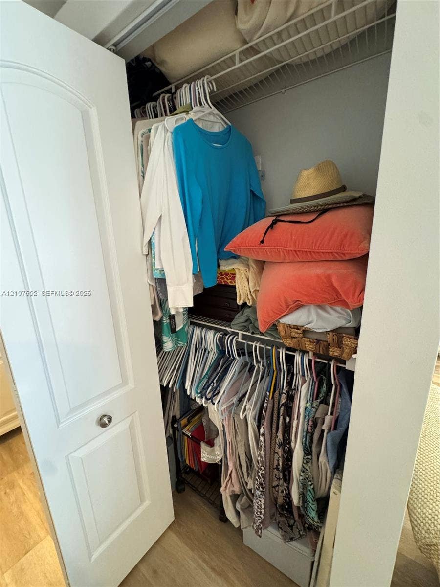Storage closet featuring a two-panel interior door with brushed metal hardware and multi-level wire shelving