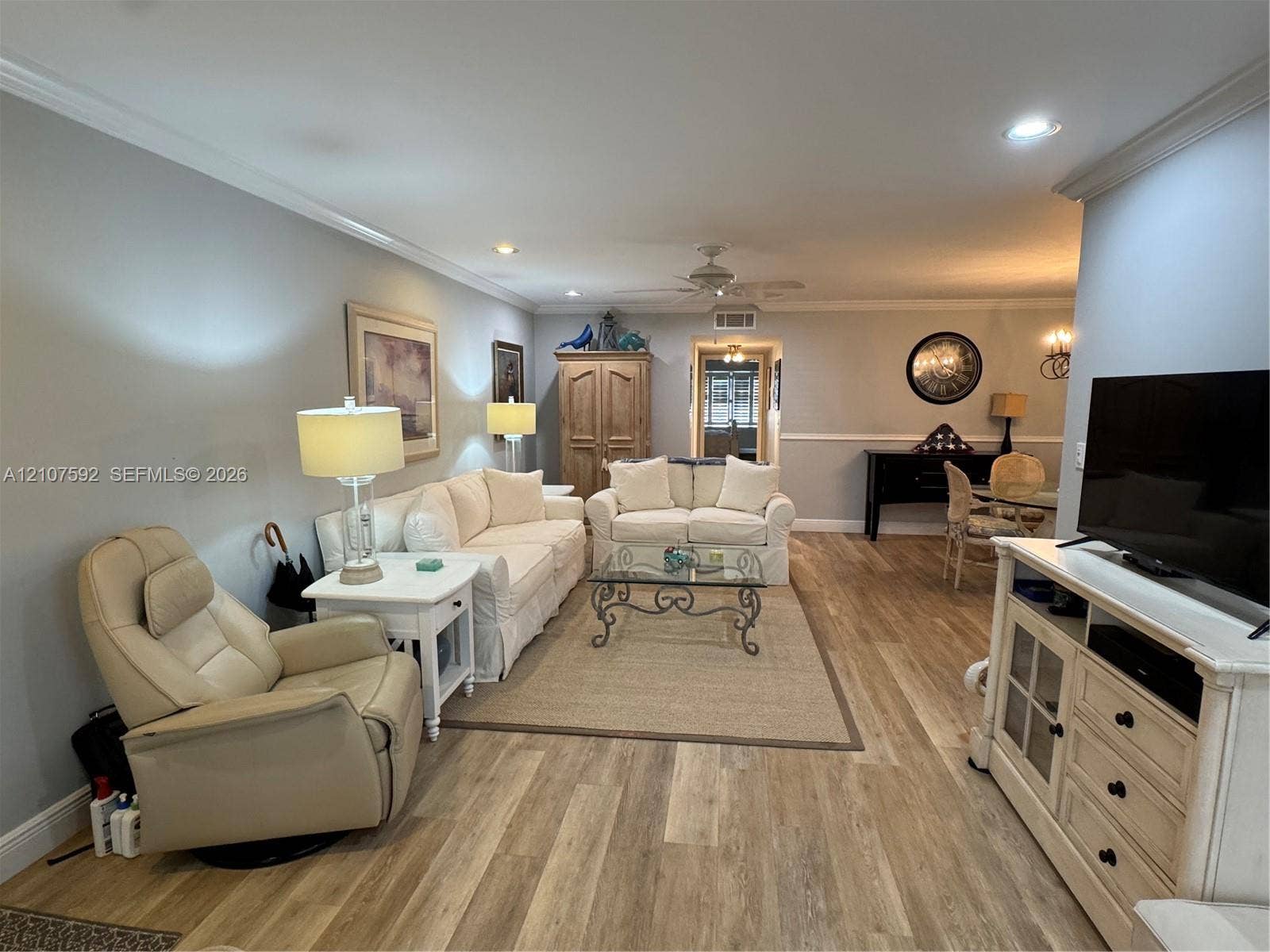 Living area featuring wood-finish flooring, crown molding, recessed lighting, and a ceiling fan