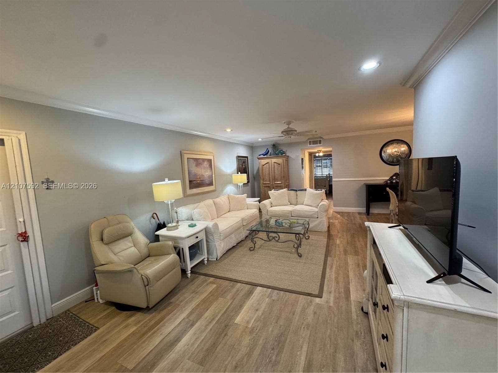 Living area featuring wood-finish flooring, crown molding, recessed lighting, and a ceiling fan