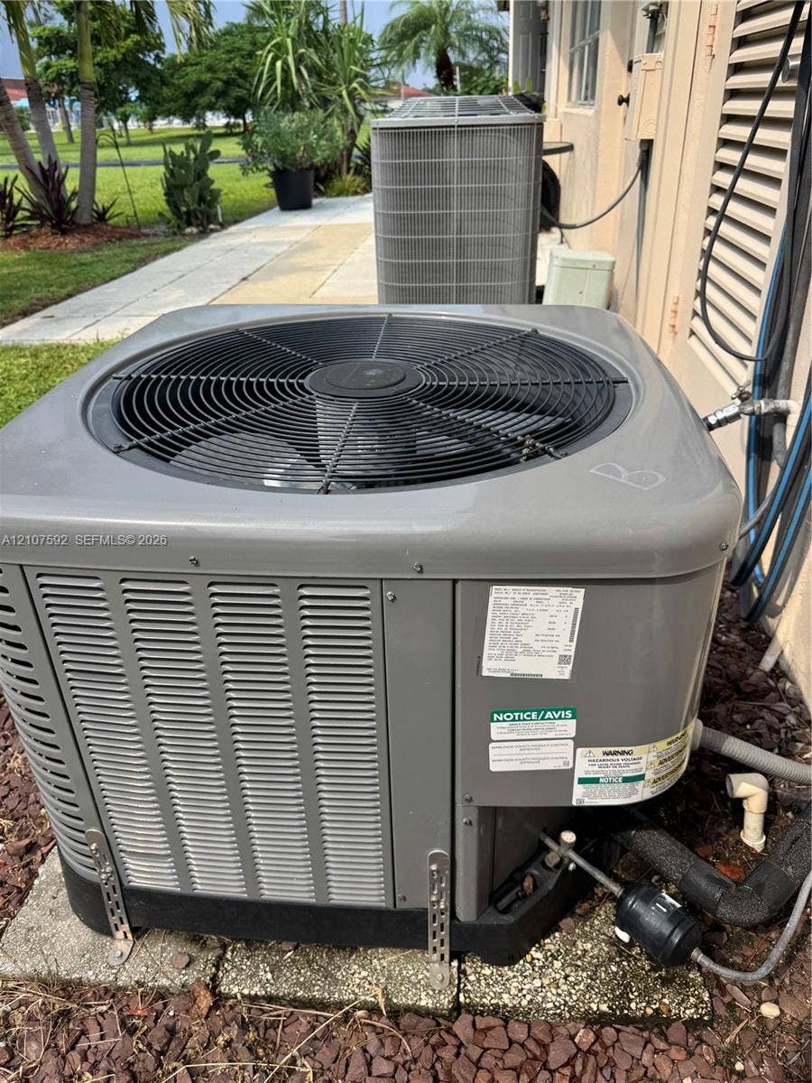 Exterior heating and cooling system featuring dual condenser units installed on a concrete foundation