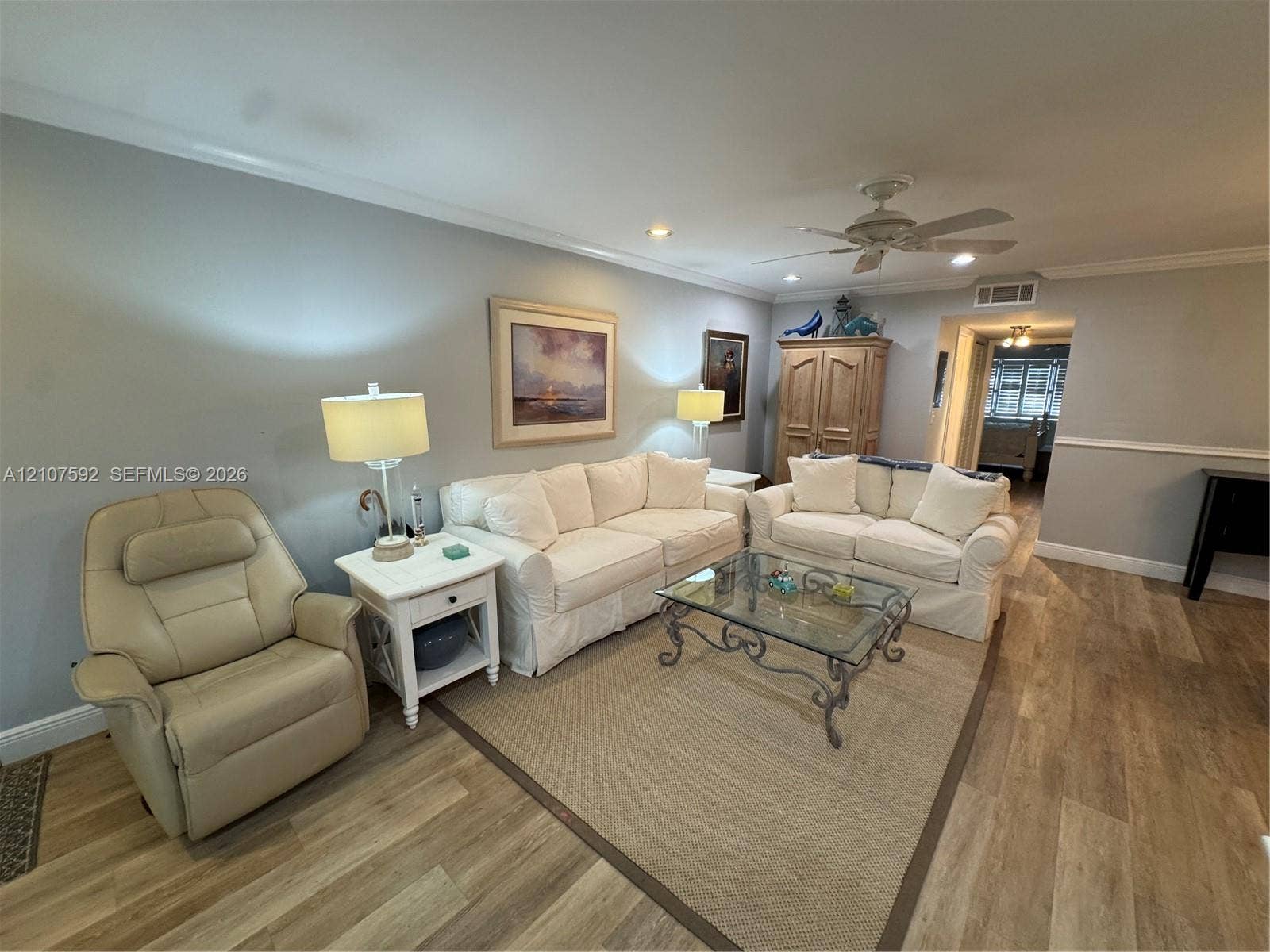 Wood-finish flooring, recessed lighting, ceiling fan, crown molding, and chair rail trim