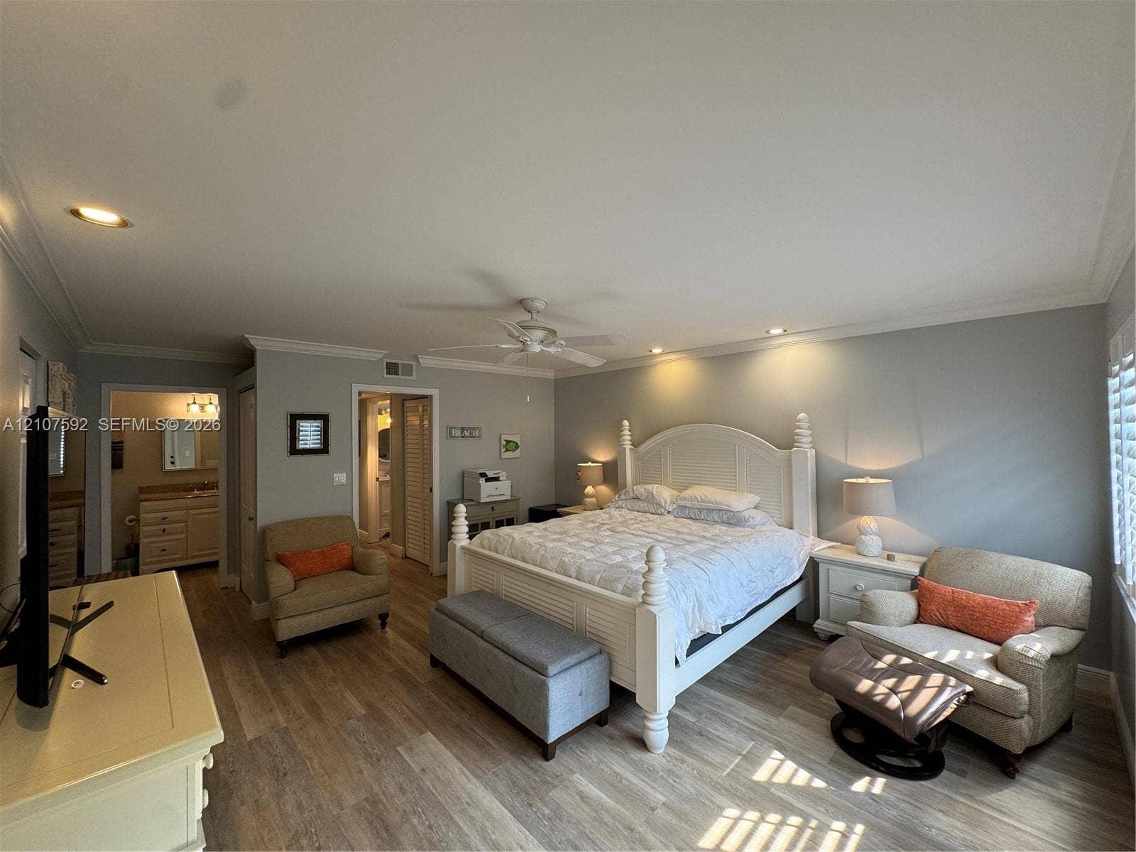 Spacious room featuring wood-finish flooring, recessed lighting, crown molding, and a central ceiling fan