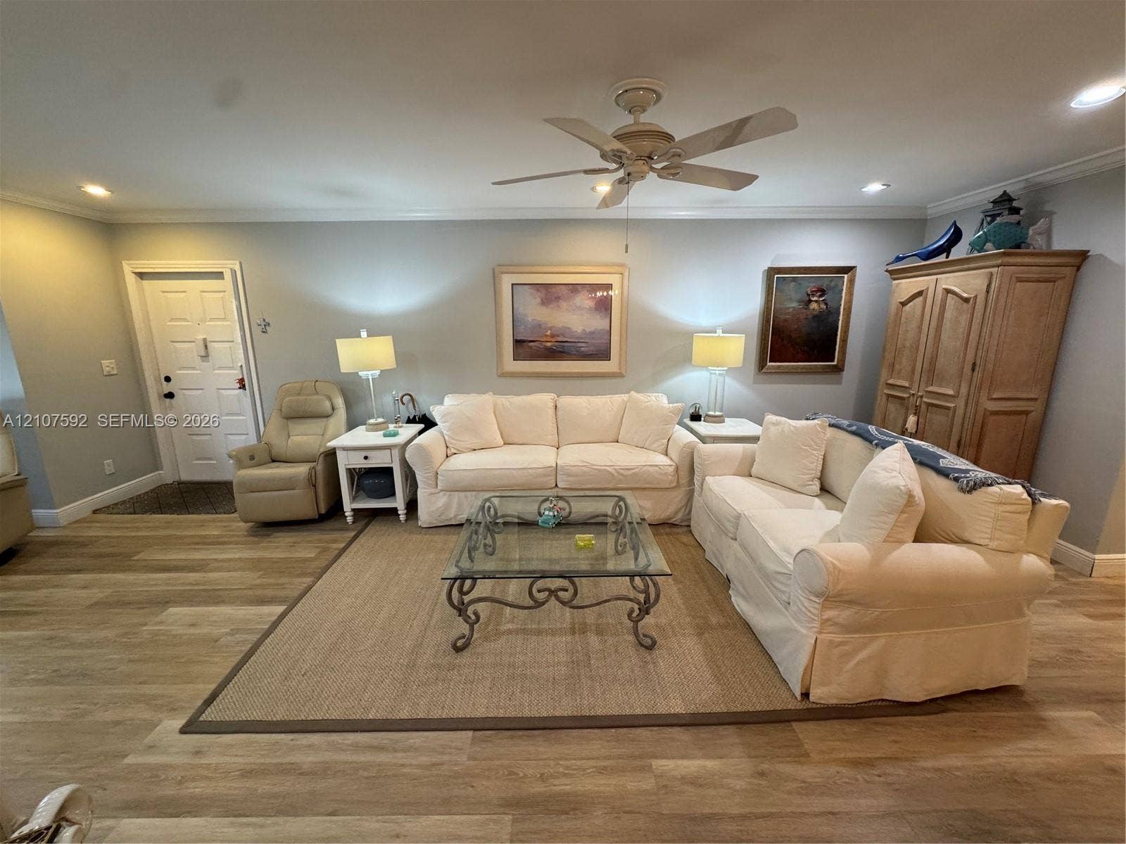 Living area featuring wood-finish flooring, a ceiling fan with integrated lighting, and recessed ceiling lights