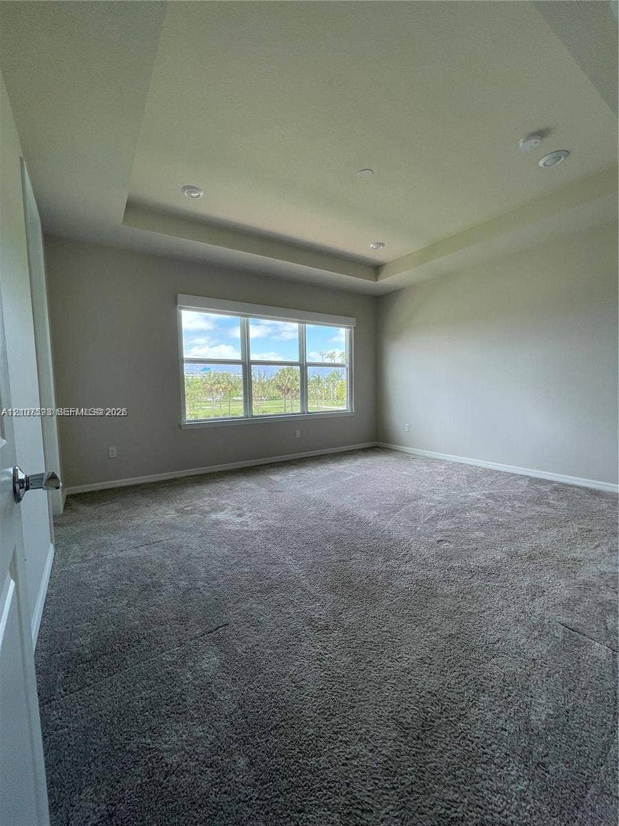 Tray ceiling featuring recessed lighting and wall-to-wall carpeting
