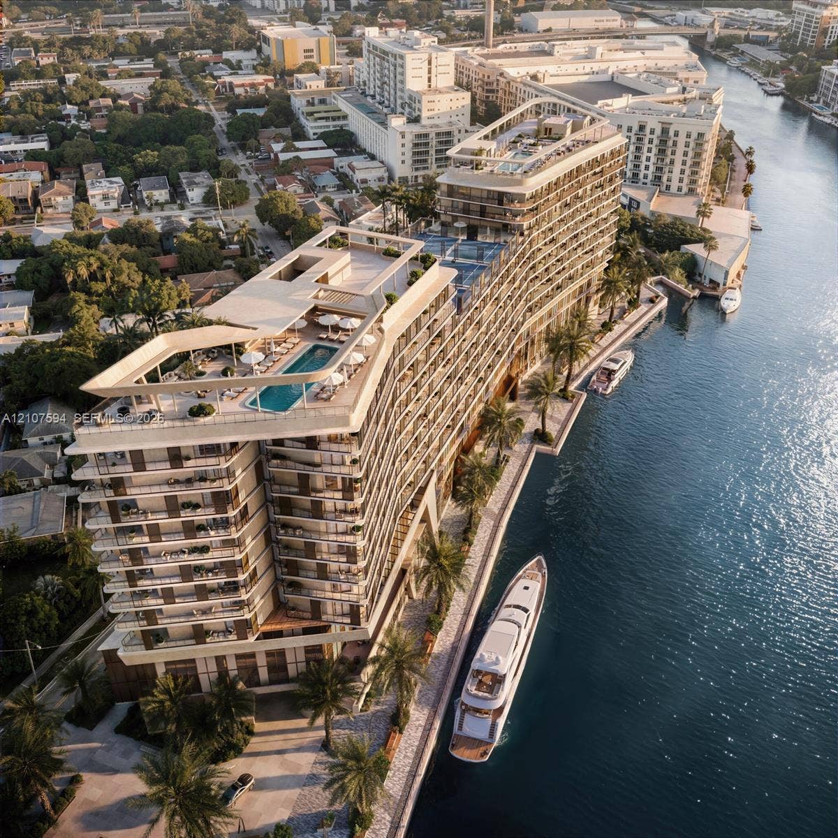 Waterfront high-rise building featuring multiple rooftop swimming pools, wrap-around balconies, a private boat slip, and landscaped grounds with palm trees