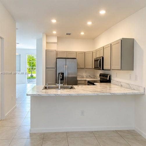 1088 NW 208th Terrace, Miami Gardens, FL 33169 Kitchen featuring light-toned cabinetry, stone-patterned countertops, stainless steel appliances, recessed ceiling lighting, and ceramic tile flooring