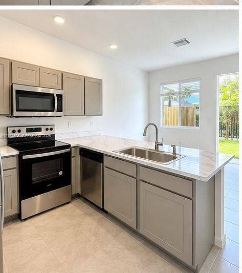 1088 NW 208th Terrace, Miami Gardens, FL 33169 Kitchen featuring light-toned cabinetry, stone-patterned countertops, stainless steel appliances, a stainless steel dual-basin sink with a gooseneck faucet, and tile flooring