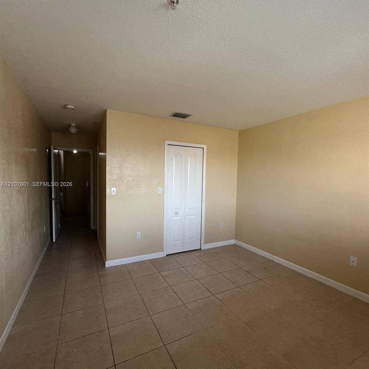 7080 NW 177th Street, #203-13, Hialeah, FL 33015 Room featuring ceramic tile flooring, neutral wall finish, and a white bi-fold closet door