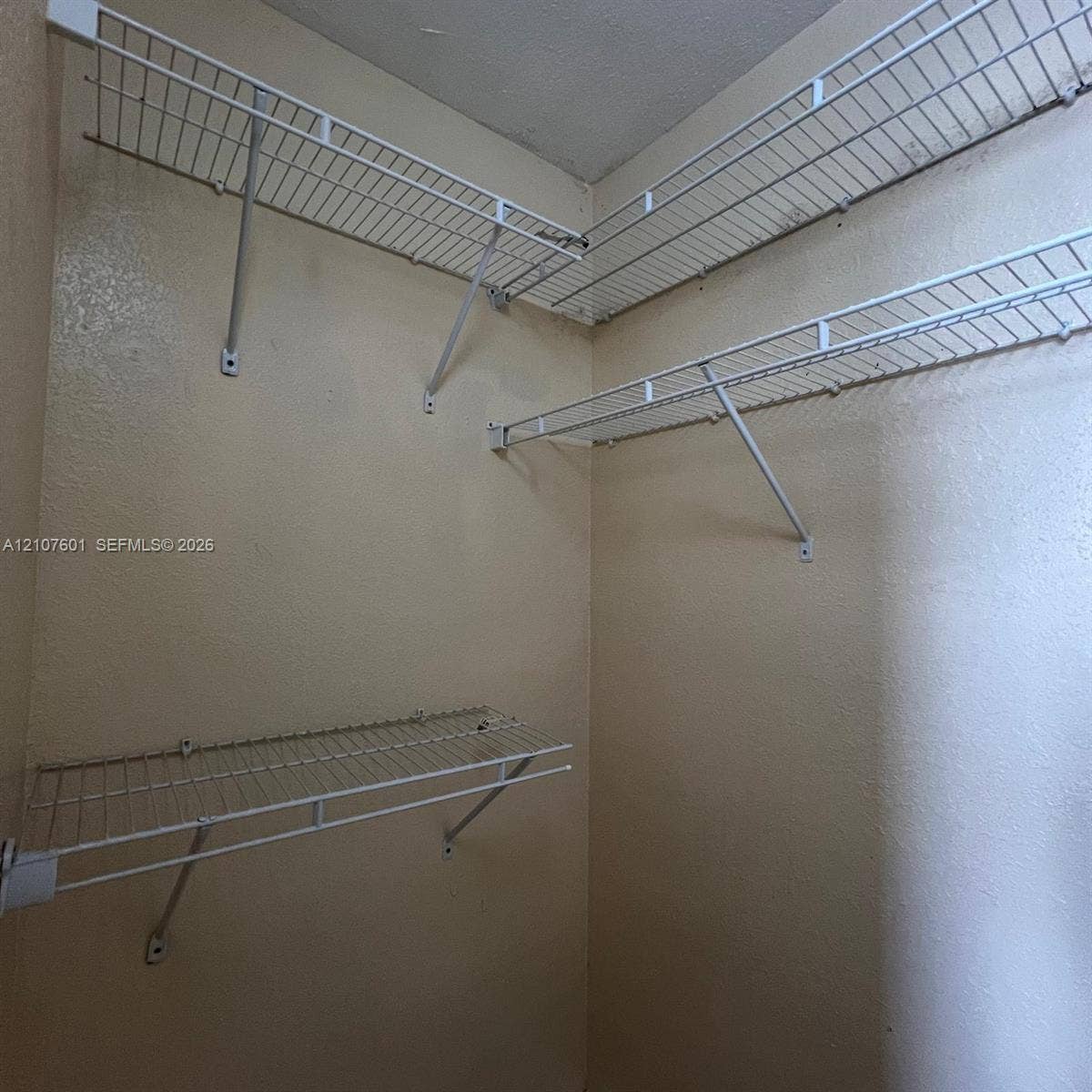 7080 NW 177th Street, #203-13, Hialeah, FL 33015 Wall-mounted white wire shelving featuring multi-level organization and structural support brackets