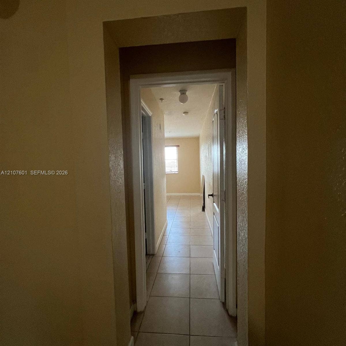 7080 NW 177th Street, #203-13, Hialeah, FL 33015 Ceramic tile flooring, white-trimmed door frames, and flush-mount ceiling light fixture