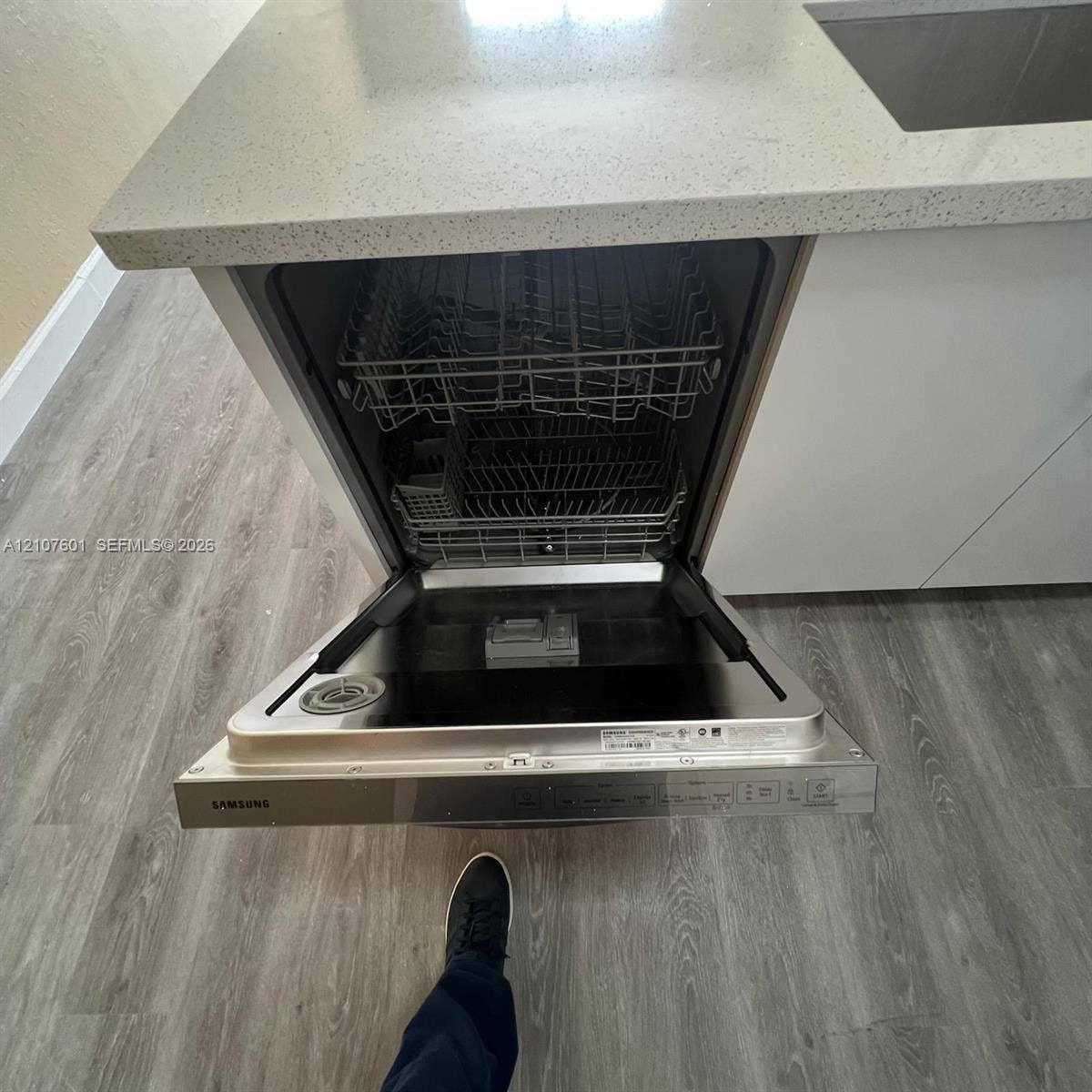 7080 NW 177th Street, #203-13, Hialeah, FL 33015 Stainless steel Samsung dishwasher, quartz countertop, white cabinetry, and wood-finish flooring