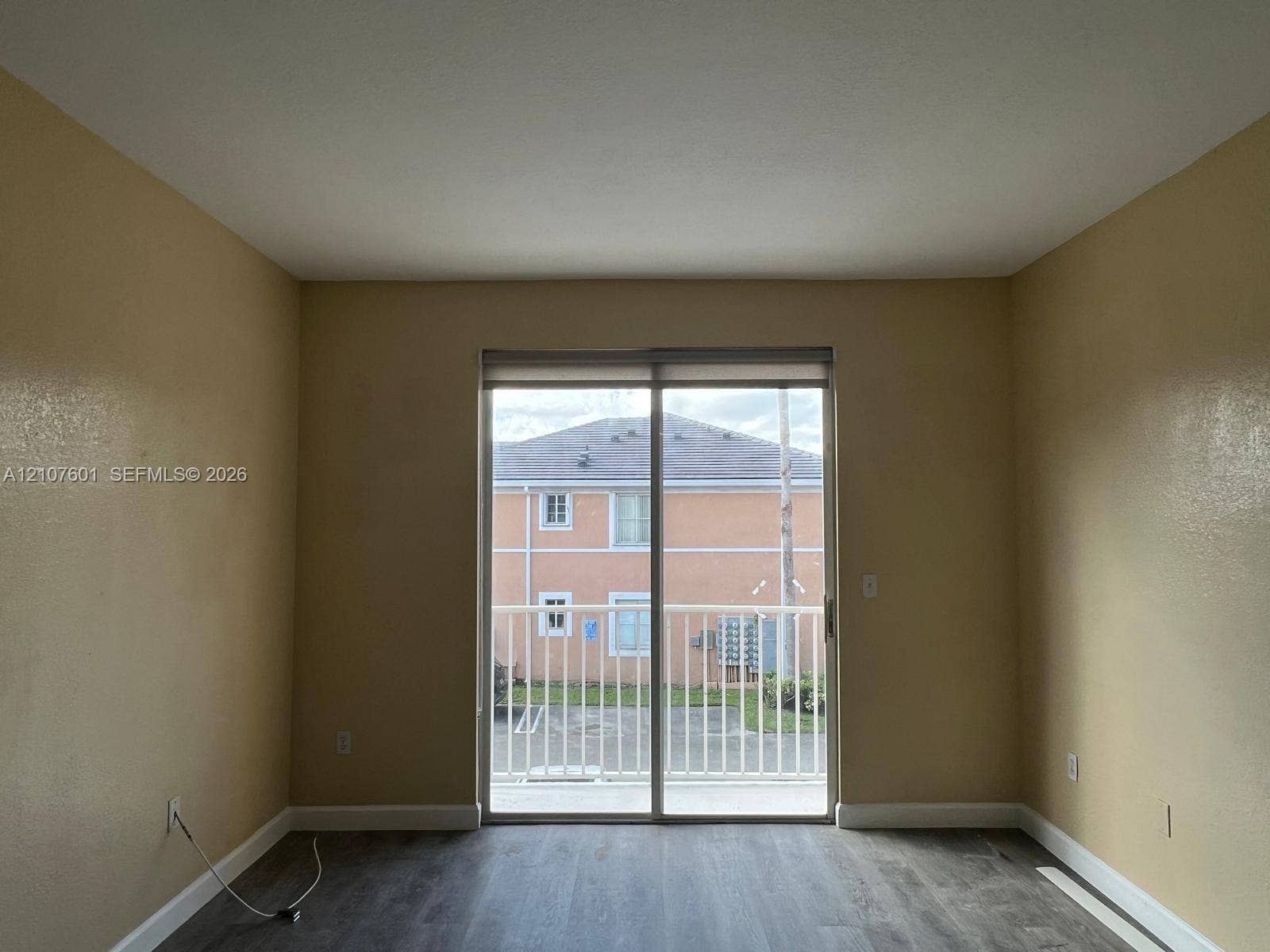 7080 NW 177th Street, #203-13, Hialeah, FL 33015 Sliding glass door with integrated roller shade, wood-finish flooring, and white metal balcony railing