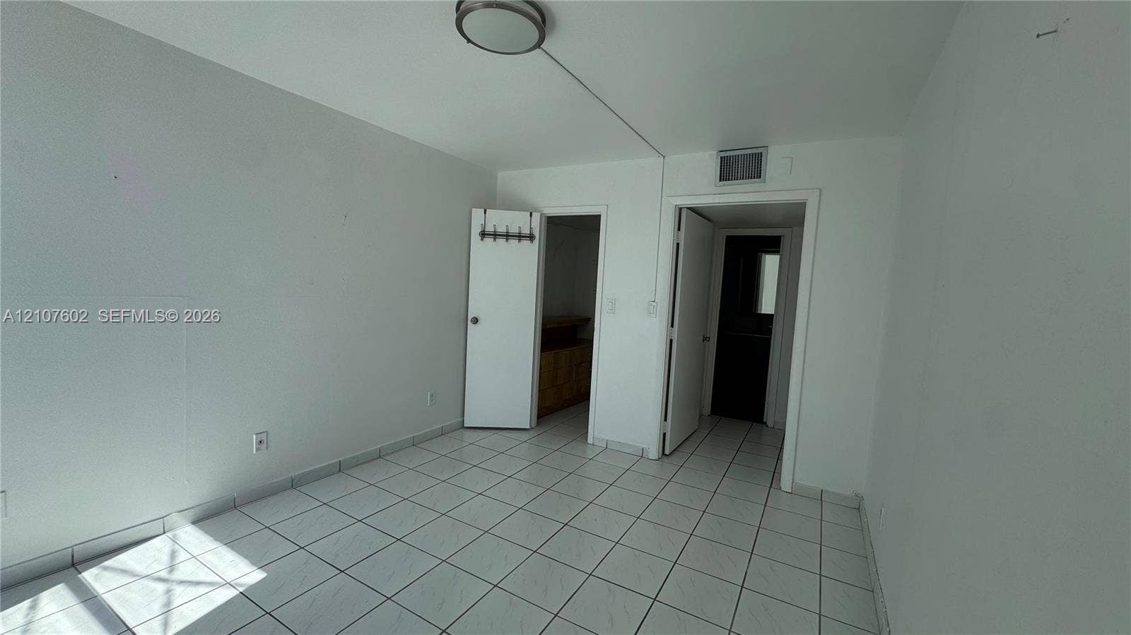 210 172nd Street, #542, Sunny Isles Beach, FL 33160 Room featuring white tile flooring, neutral wall paint, and a circular flush-mount ceiling light fixture