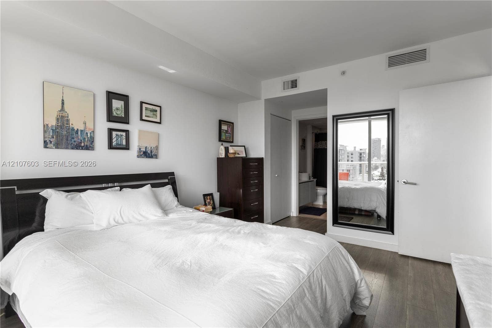 4250 Biscayne Boulevard, #1418, Miami, FL 33137 Wood-finish flooring, full-length wall mirror with a black frame, and ceiling-integrated climate control system
