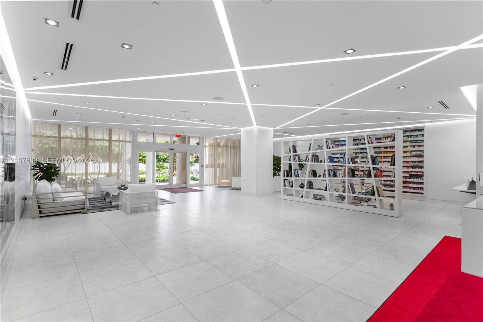 4250 Biscayne Boulevard, #1418, Miami, FL 33137 Large-format tile flooring, geometric ceiling with recessed linear lighting, full-height glass entrance doors, and built-in architectural shelving