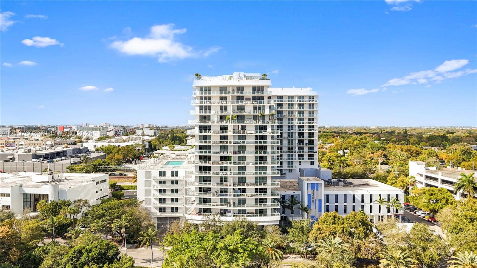 4250 Biscayne Boulevard, #1418, Miami, FL 33137 High-rise residential building featuring private recessed balconies, a rooftop pool, glass railing systems, and extensive manicured landscaping