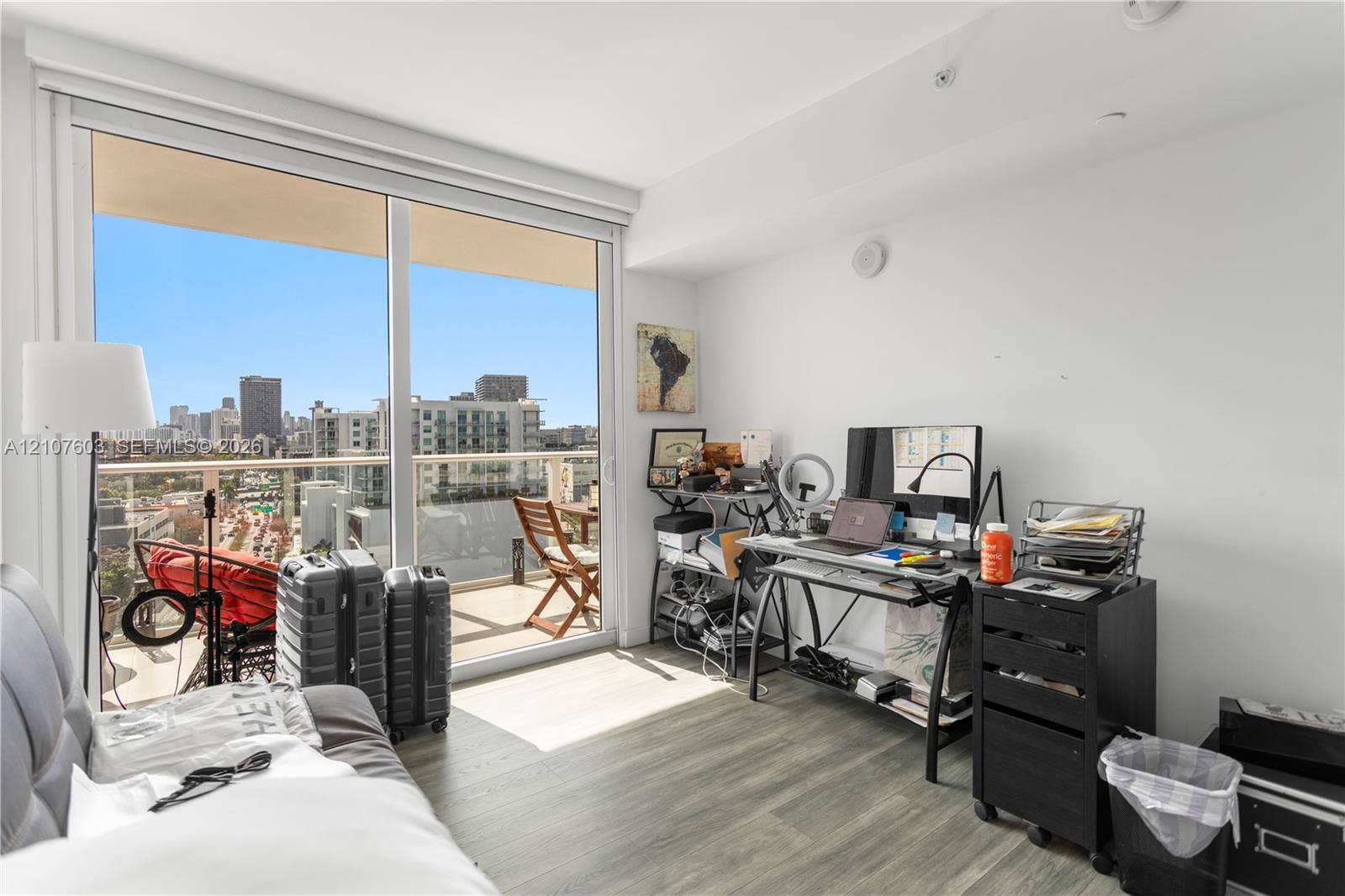 4250 Biscayne Boulevard, #1418, Miami, FL 33137 Floor-to-ceiling sliding glass door, private balcony, wood-finish flooring, and expansive urban scenery