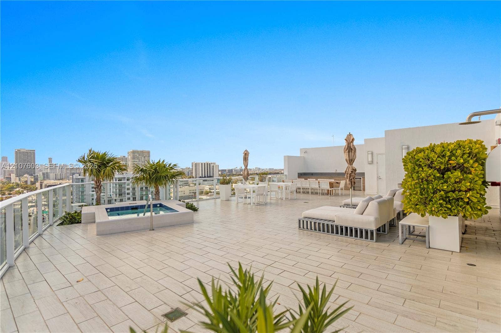 4250 Biscayne Boulevard, #1418, Miami, FL 33137 Expansive rooftop terrace featuring large-format tile flooring, a built-in spa, glass railing, and integrated exterior wall lighting