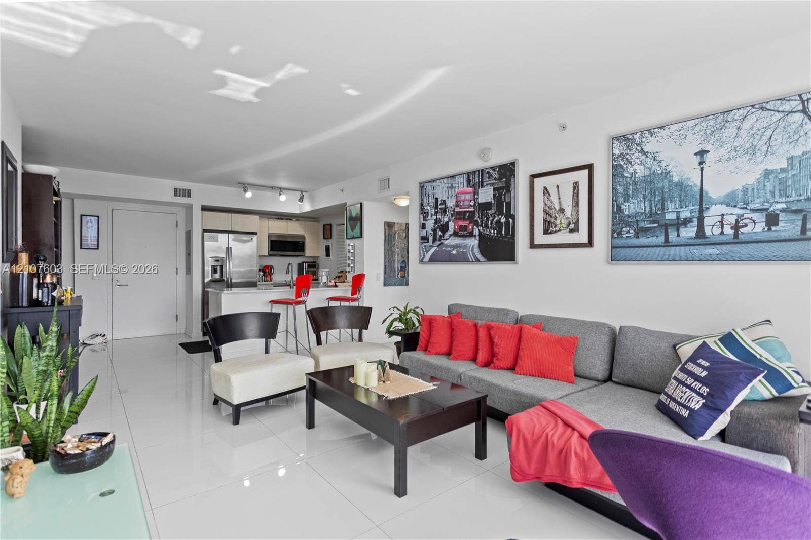 4250 Biscayne Boulevard, #1418, Miami, FL 33137 Open-concept interior featuring high-gloss tile flooring, smooth ceilings, and a kitchen equipped with stone-surfaced countertops and stainless-steel appliances